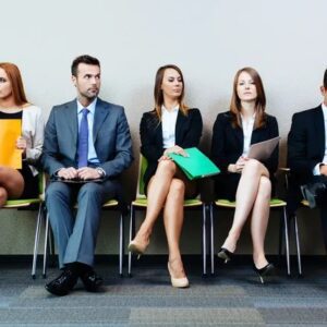 A group of people sitting in chairs waiting for an interview.