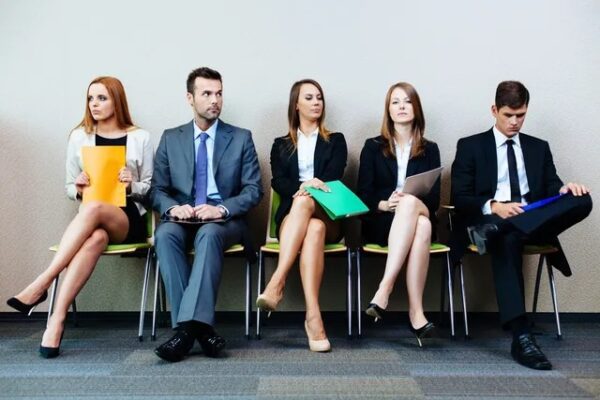 A group of people sitting in chairs waiting for an interview.