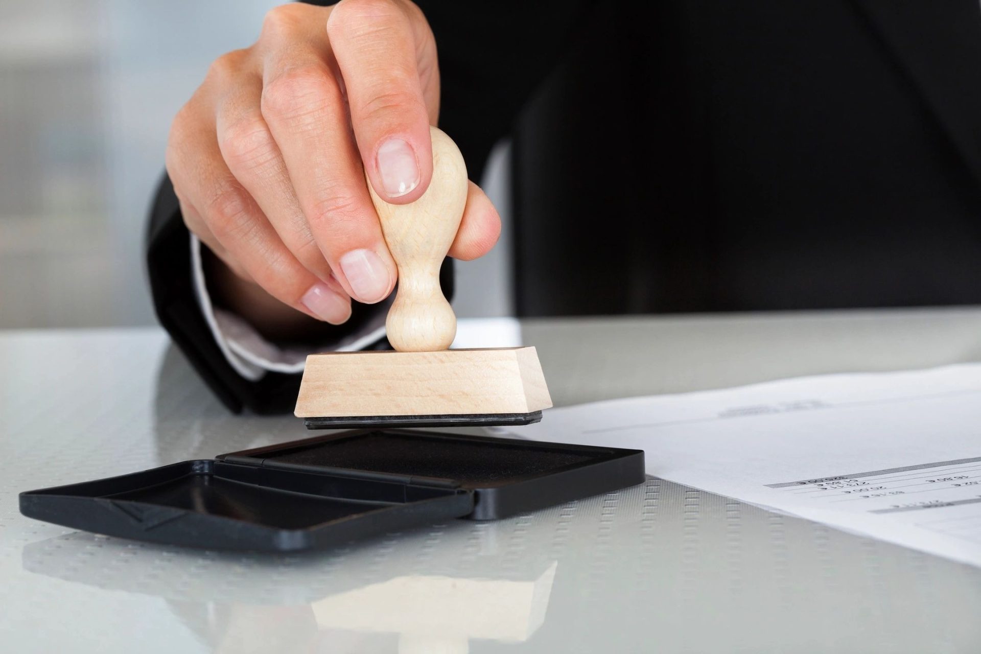 A person is using a rubber stamp on a table.