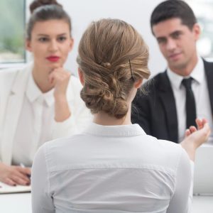 A woman is sitting in front of two men.